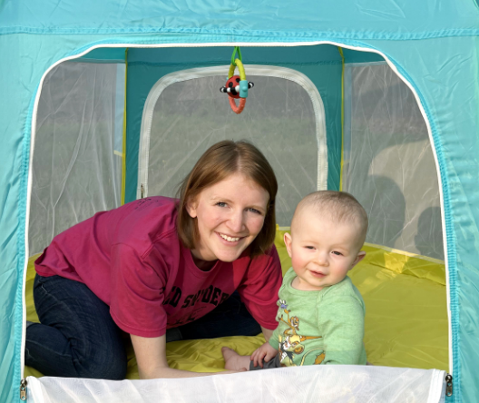 Image of Ashley Totin with an infant inside a play tent.