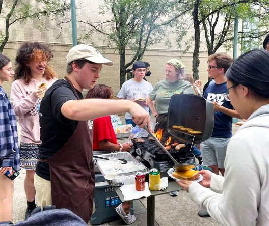 Lance Miller grilling and serving food to other people.