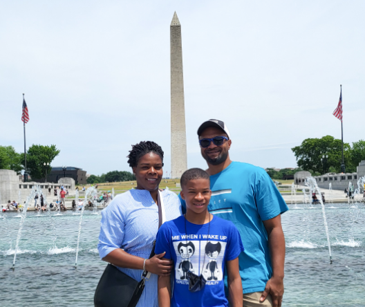 Photo of Tymeeka Middleton with her husband and son in front of the Washington Monument and WWII memorial in Washington, DC.