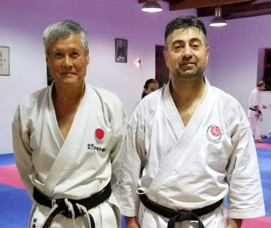 Image of Victor Veliadis in a Karate dojo with his instructor.