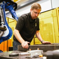 Photo of an ARM Institute employee testing a robotic arm