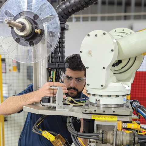 Photo of an IACMI employee working at a machine.