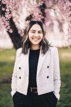 Photo of Angela Cleri standing under cherry blossoms