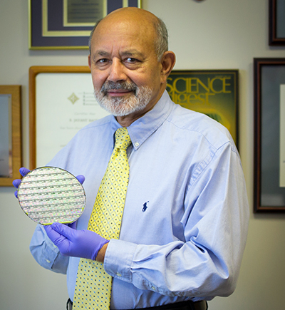 Photograph of Jay Baliga, who developed the PRESiCE process holding a wafer of silicon carbide devices.  