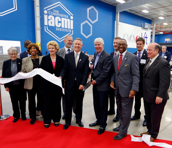 Photograph of (from left): Michigan State University President Lou Anna K. Simon, Office of Naval Research Program Manager Johnnie Deloach, Congresswoman Brenda Lawrence, Senator Debbie Stabenow, Dir. of the IACMI Vehicle Scale Up Facility Ray Boeman, IACMI Interim CEO John Hopkins, Michigan Governor Rick Snyder, Deputy Dir. of the Dept of Energy Adv. Manufacturing Office Rob Ivester, LIFT Executive Dir. Lawrence Brown, LIFT Technology Development Committee Chair Jeffrey Nichols, & Detroit Mayor Mike Duggan.